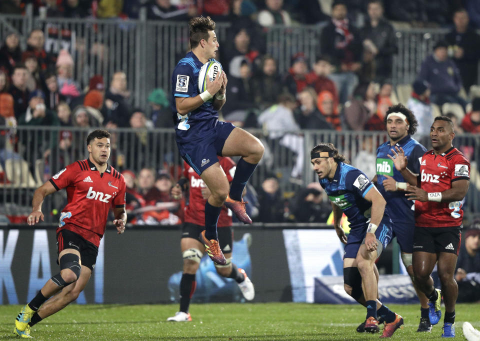 Blues Harry Plummer leaps in the air to take a catch during their Super Rugby match against the Crusaders in Christchurch, New Zealand, Saturday, May 25, 2019. (AP Photo/Mark Baker)