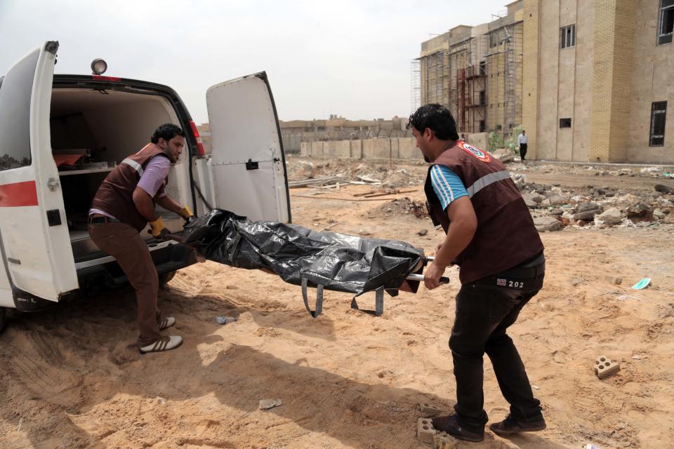 Medics evacuate a body at a Shiite private college following an attack by militants, in Baghdad’s eastern neighborhood of Ur, Iraq, Sunday, April 20, 2014. A suicide bomber with an explosives belt attacked the main gate of a Shiite private college while three militants attacked the back gate, leaving several people dead and over a dozen people wounded. Security forces killed all of the attackers. (AP Photo/Khalid Mohammed)