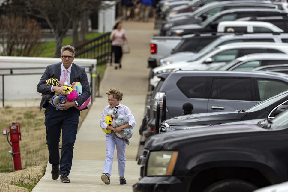 A man and young boy carrying several plush toys leave the funeral service held for The Covenant School shooting victim Evelyn Dieckhaus at the Woodmont Christian Church Friday, March 31, 2023, in Nashville, Tenn. The toys were donated by an anonymous donor for all the children in attendance. (AP Photo/Wade Payne)