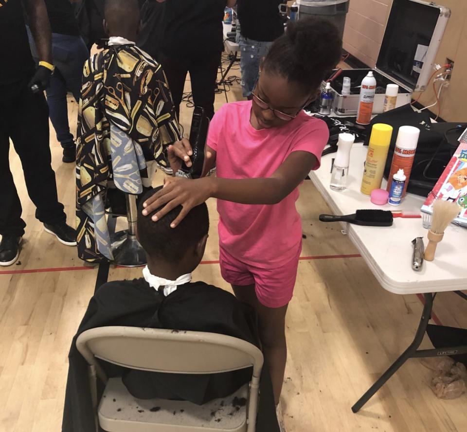 Neijae giving a haircut. (Photo: Courtesy of P. Michael Boone)