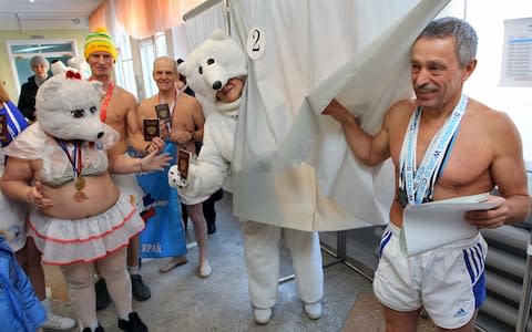 Members of an ice-swimming club cast their votes at a polling station in Barnaul in Siberia - Credit: Andrei Kasprishin/Reuters