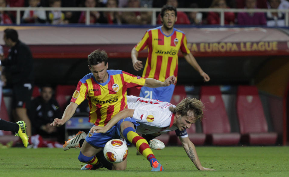 Sevilla's Ivan Rakitic, right, and Valencia's Pablo Piatti, left, fight for the ball during their Europa League semifinal first leg soccer match at the Ramon Sanchez Pizjuan stadium, in Seville, Spain on Thursday, April 24, 2014. (AP Photo/Miguel Angel Morenatti)