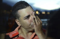 <p>Gilberto Villegas, a ferry passenger who survived after it sank in a reservoir, cries as he talks to the press in Guatape, Colombia, June, 25, 2017. Villegas said two of his relatives are still missing. (Luis Benavides/AP) </p>