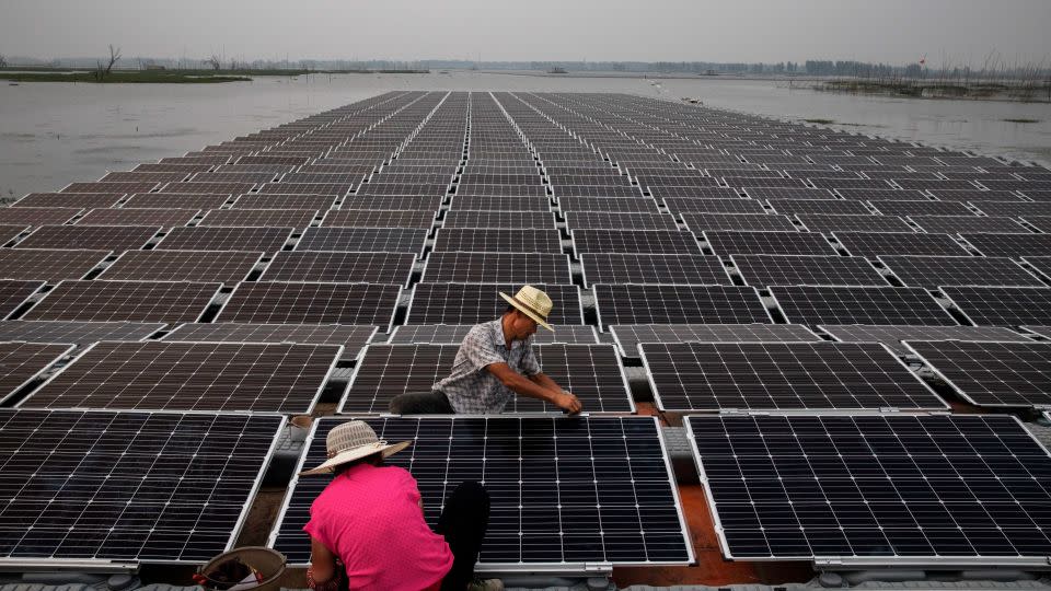 Workers prepare part of a large floating solar farm project under construction in June 2017 in Huainan, Anhui province, China. - Kevin Frayer/Getty Images
