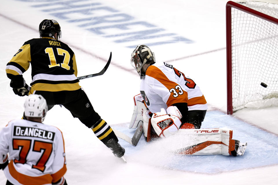 Pittsburgh Penguins' Bryan Rust (17) backhands a shot past Philadelphia Flyers goaltender Samuel Ersson (33) for a goal during the second period of an NHL hockey game in Pittsburgh, Sunday, April 2, 2023. (AP Photo/Gene J. Puskar)