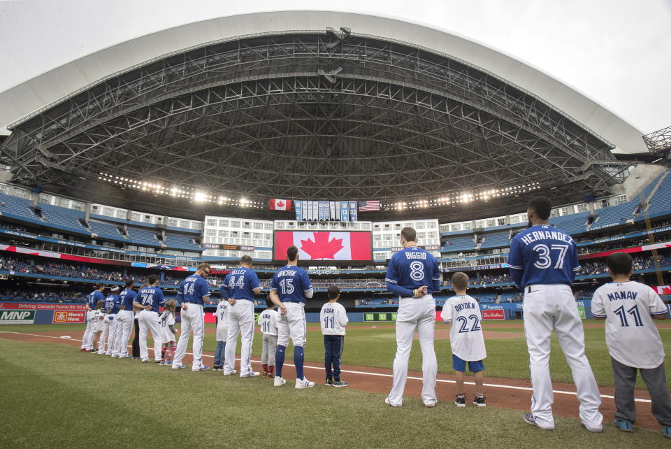 Toronto Blue Jays players line up with Junior Jays for the singing of the national anthems prior to a baseball game against the Tampa Bay Rays in Toronto, Sunday, Sept. 29, 2019. (Fred Thornhill/The Canadian Press via AP)