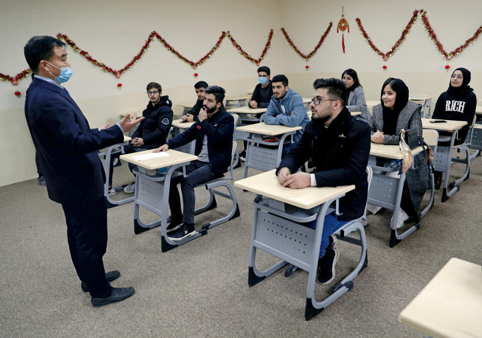 Chinese lecturer Zhiwei Hu speaks to students in the Chinese language department at Salahaddin University in Irbil, Iraq, Wednesday, Jan. 19, 2021. The Chinese language school in northern Iraq is attracting students who hope to land jobs with a growing number of Chinese companies in the oil, infrastructure, construction, and telecommunications sectors in the region. (AP Photo/Khalid Mohammed)