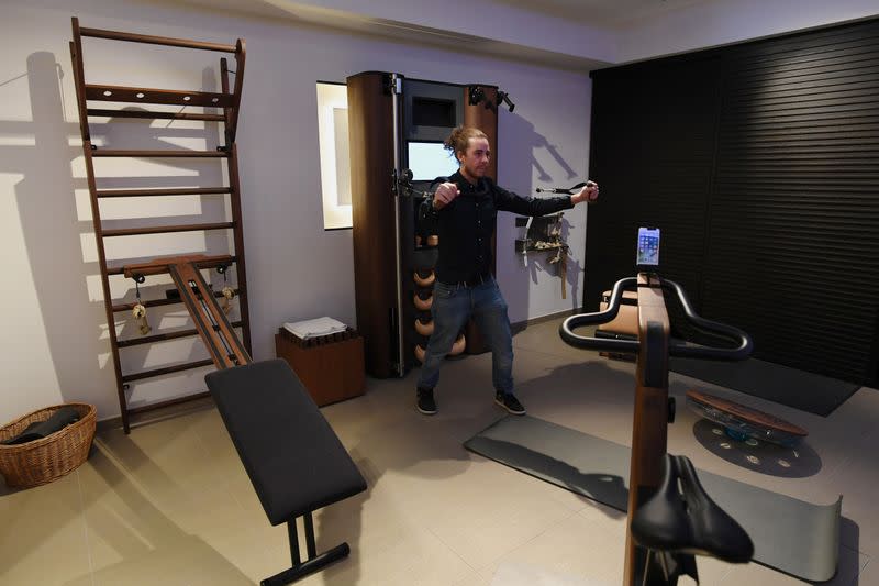 A man tries out exercising equipment in a showroom of U.S. gym equipment manufacturer WaterRower in Munich