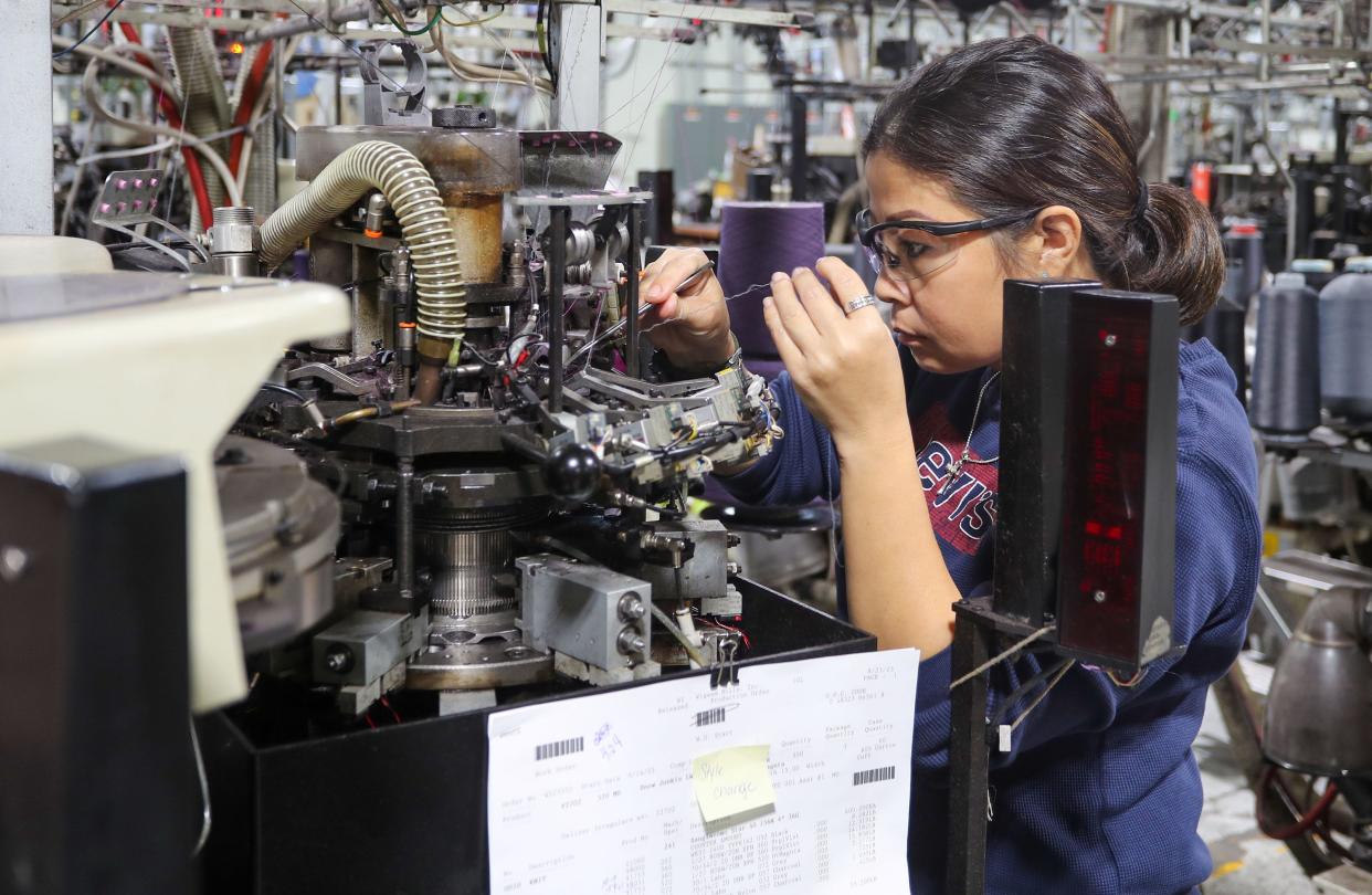 A Wigwam employee checks the threading of a sock making machine, Thursday, October 5, 2023, in Sheboygan, Wis.