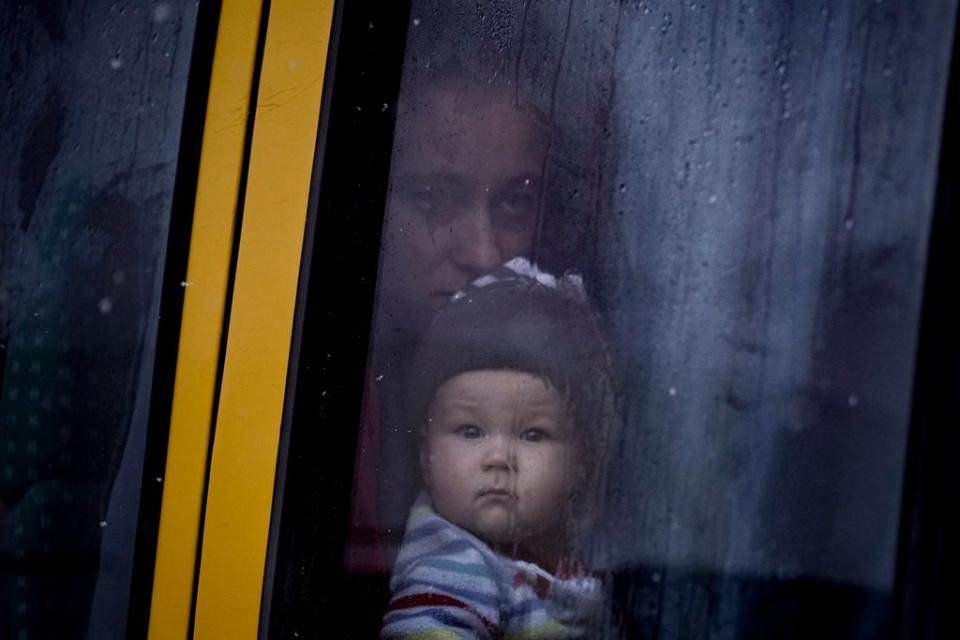 A woman and child who were evacuated from areas on the outskirts of the Ukrainian capital look out the window of a bus after arriving at a triage point in Kyiv (AP)