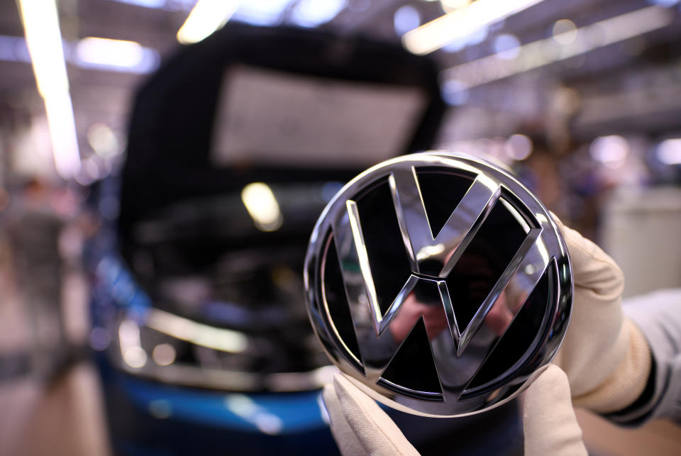 An employee holds a Volkswagen logo at the Volkswagen plant in Wolfsburg, Germany. Photo: Reuters/Fabian Bimmer