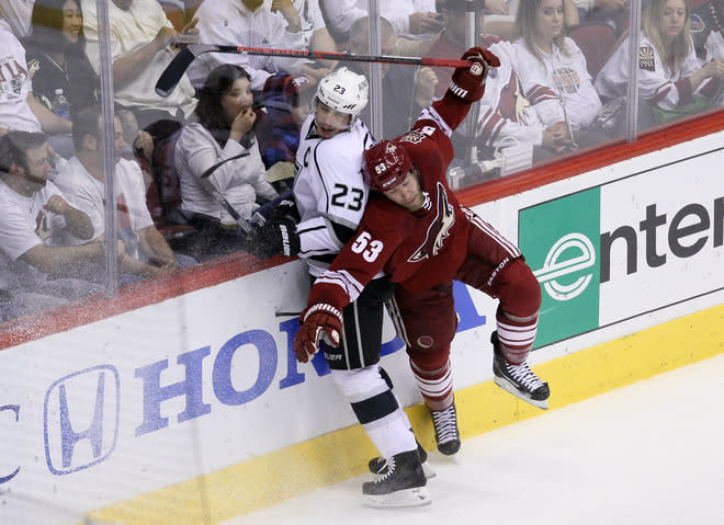 GLENDALE, AZ - MAY 15: Derek Morris #53 of the Phoenix Coyotes spins away from a check by Dustin Brown #23 of the Los Angeles Kings in the first period of Game Two of the Western Conference Final during the 2012 NHL Stanley Cup Playoffs at Jobing.com Arena on May 15, 2012 in Phoenix, Arizona. (Photo by Jeff Gross/Getty Images)