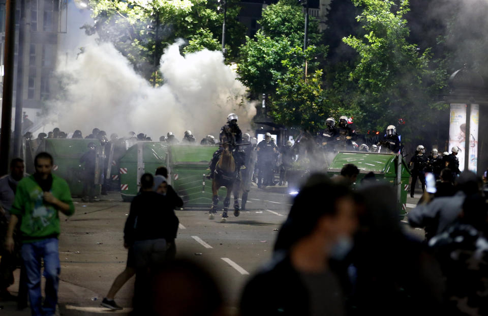 Sebian police officers disperse protesters in front of Serbian parliament building in Belgrade, Serbia, Wednesday, July 8, 2020. Thousands of people protested the Serbian president's announcement that a lockdown will be reintroduced after the Balkan country reported its highest single-day death toll from the coronavirus Tuesday. (AP Photo/Darko Vojinovic)