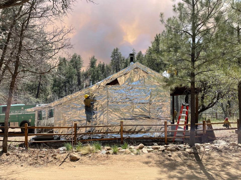 Fire crews wrap the Palace Station Historic Stagecoach Stop Cabin as the Crooks Fire continued to burn near Prescott.