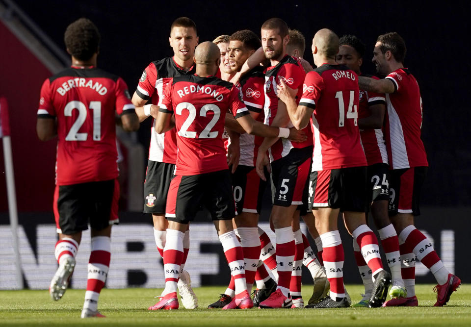 Southampton's Che Adams, centre, is congratulated by teammates after scoring his team's first goal during the English Premier League soccer match between Southampton and Manchester City at St. Mary's Stadium in Southampton, England, Sunday, July 5, 2020. (AP Photo/Will Oliver,Pool)