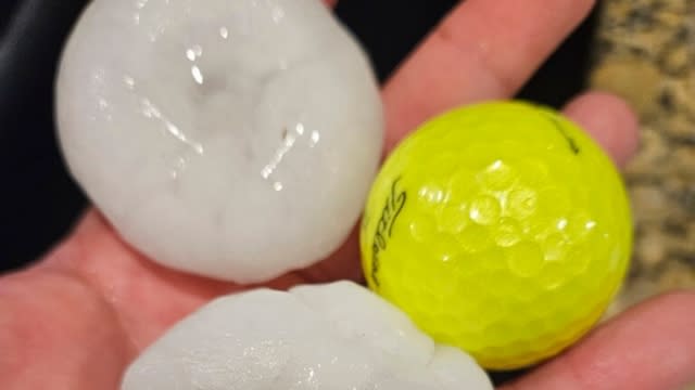 Person holds hail chunks the size of a golf ball