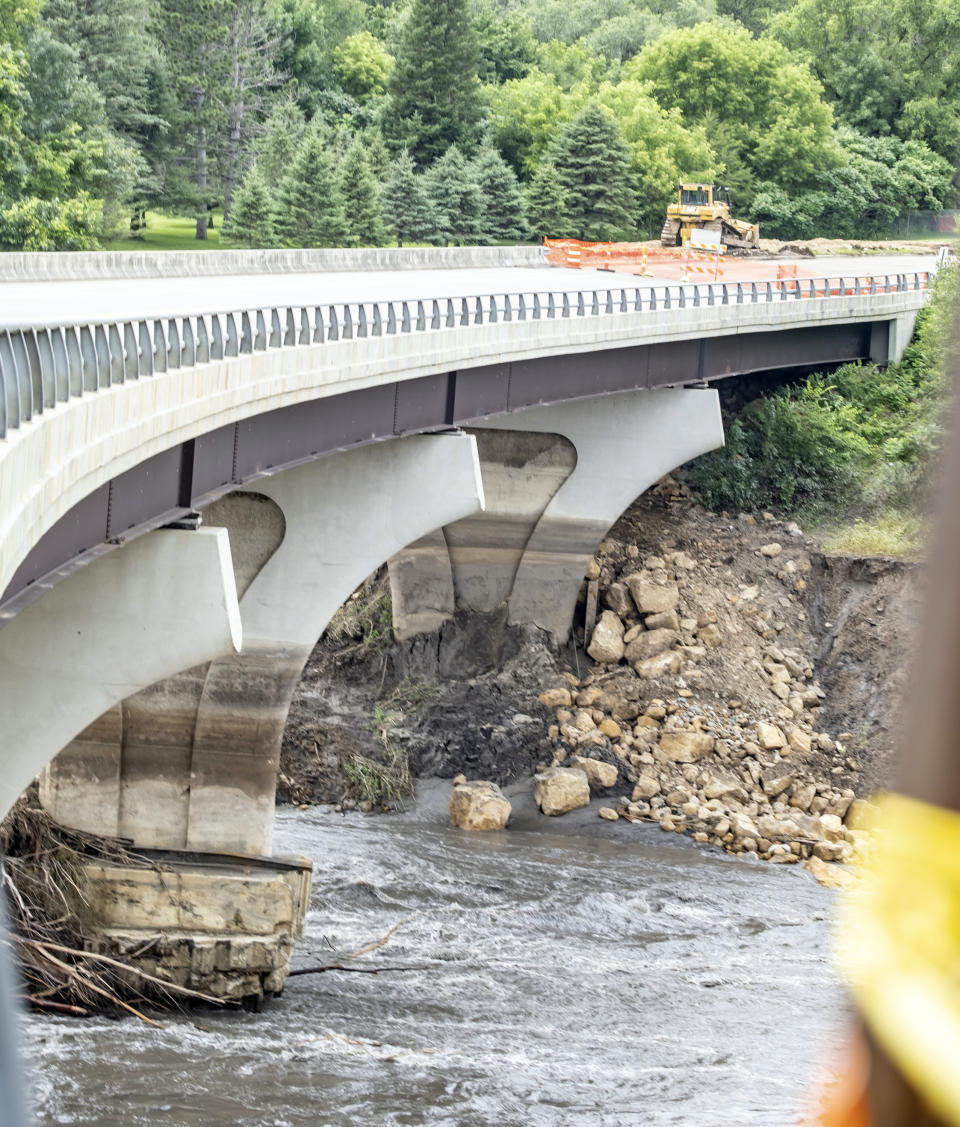 Emergency management officials have expressed concern for the structural stability of the Blue Earth County Road 9 bridge that runs over the Blue Earth River, Tuesday, July 2, 2024, in Rapidan, Minn. Fallen water levels have left the base of the bridge partially exposed, risking further instability. Minnesota Gov. Tim Walz and local officials shared concerns about the bridge's future during a visit Tuesday. (Casey Ek/The Free Press via AP)