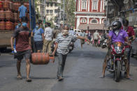 MUMBAI, INDIA - MARCH 23: People carry gas cylinder during lockdown due to Covid 19 pandemic at Girgaum, on March 23, 2020 in Mumbai, India. (Photo by Pratik Chorge/Hindustan Times via Getty Images)