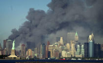 <p>Thick smoke billows into the sky from the area behind the Statue of Liberty, lower left, where the World Trade Center was, on Tuesday, Sept. 11, 2001. (AP Photo/Daniel Hulshizer)</p> 