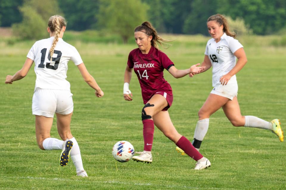 Charlevoix's Mikayla Sharrow (middle) works between a pair of Glen Lake defenders during Wednesday semifinal.