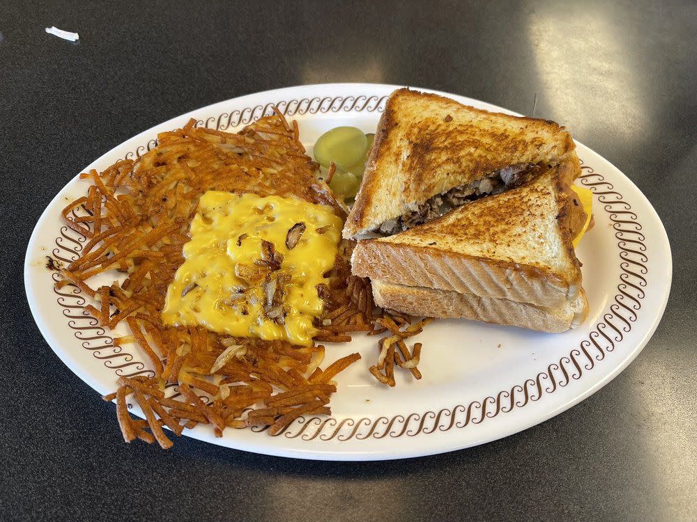 a breakfast sandwich with hash browns from waffle house