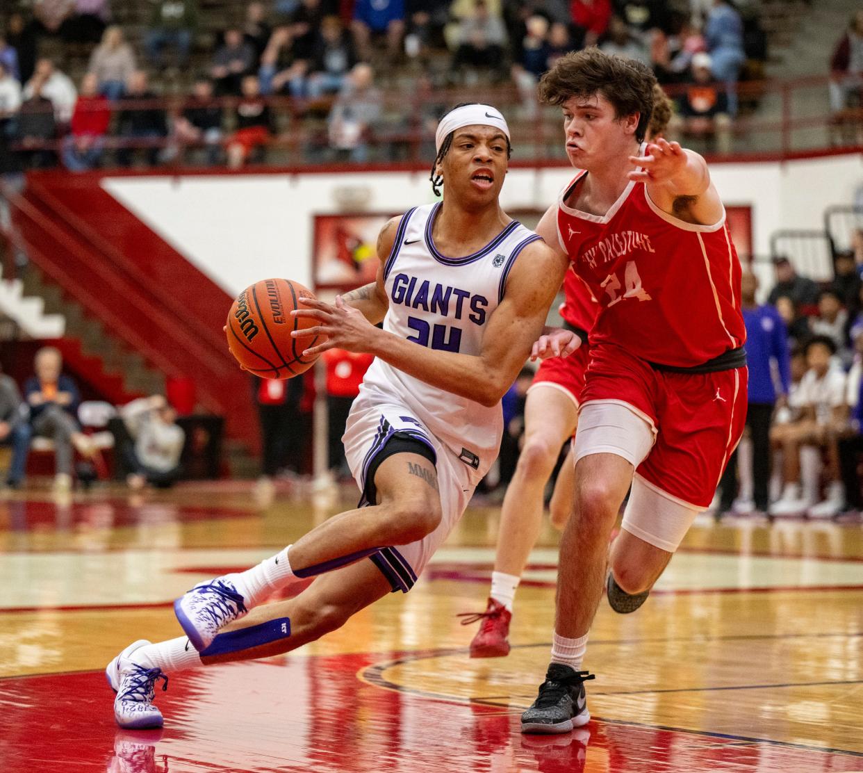 Ben Davis High School senior Karl Windham Jr. (24) races toward the basket while being defended by New Palestine High School junior Benjamin Slagley (24) during the first half of an IHSAA Class 4A Boys Regional basketball game, Saturday, March 9, 2024, at Southport High School.