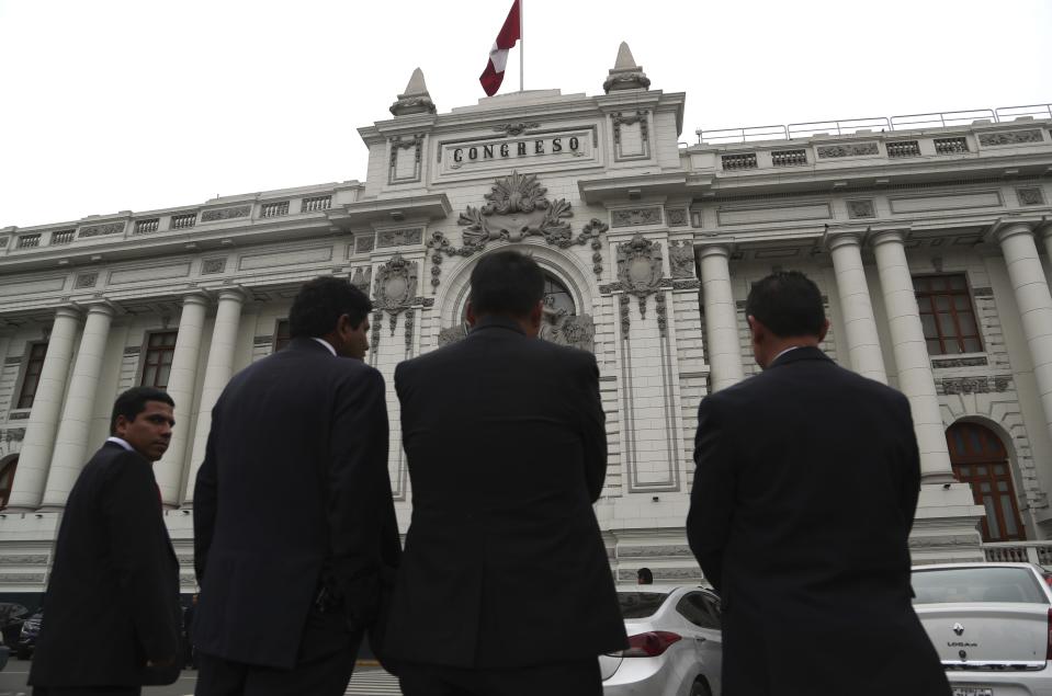 Security officers stand outside Congress where lawmakers are expected to push forward a vote to select an almost-full slate of new magistrates to the Constitutional Tribunal, in Lima, Peru, Monday, Sept. 30, 2019. Lawmakers are pushing forward the vote despite President Martín Vizcarra's warning the move threatens his fight against corruption and that he'll dissolve the opposition-controlled legislature. (AP Photo/Martin Mejia)