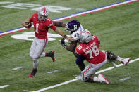 Ohio State quarterback Justin Fields (1) eludes Northwestern defensive lineman Adetomiwa Adebawore (49) as Ohio State offensive tackle Nicholas Petit-Frere (78) blocks during the second half of the Big Ten championship NCAA college football game, Saturday, Dec. 19, 2020, in Indianapolis. (AP Photo/Darron Cummings)