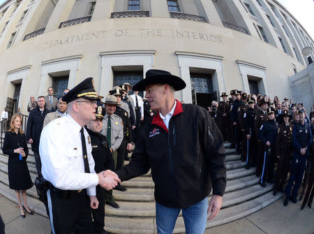 New Interior Secretary Ryan Zinke (R) greets employees after riding in on horseback with a U.S. Park Police horse mounted unit to report for his first day of work at the Interior Department in Washington, U.S., March 2, 2017. Tami Heilemann/Department of Interior/Handout via REUTERS