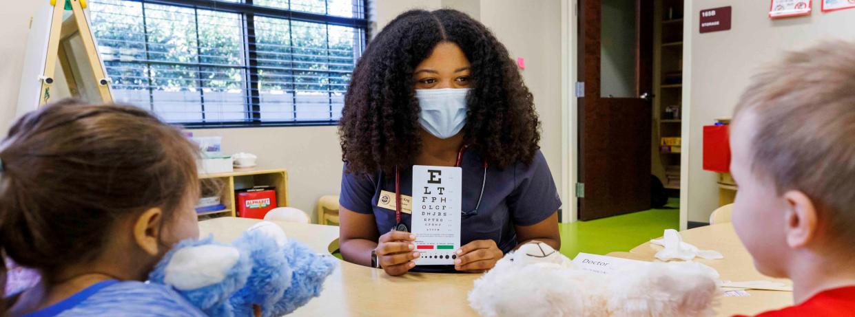 Khari King, a second-year medical student at the FSU College of Medicine, explains how a vision test is conducted during the Teddy Bear Clinic at FSU’s Childcare and Early Learning Program.