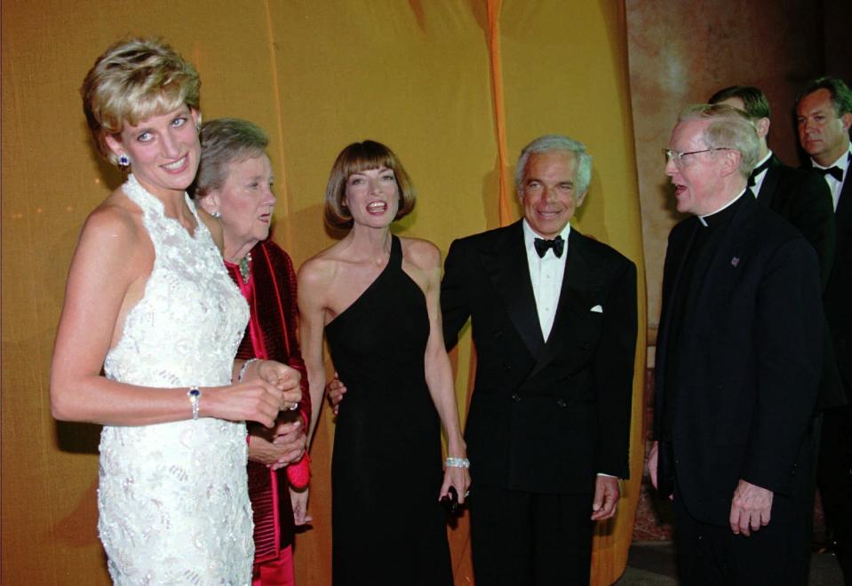 ARCHIVO – La princesa Diana sonríe en la recepción al saludar a los invitados a un evento de recaudación de fondos para la investigación del cáncer de mama en el Museo National Building el 24 de septiembre de 1996 en Washington. De izquierda a derecha la princesa Diana, la propietaria del Washington Post Katherine Graham, la editora en jefe de la revista Vogue Anna Wintour, el diseñador Ralph Lauren y el rector de la Universidad de Georgetown reverendo Leo J. O'Donovan. (Foto AP/J. Scott Applewhite, archivo)