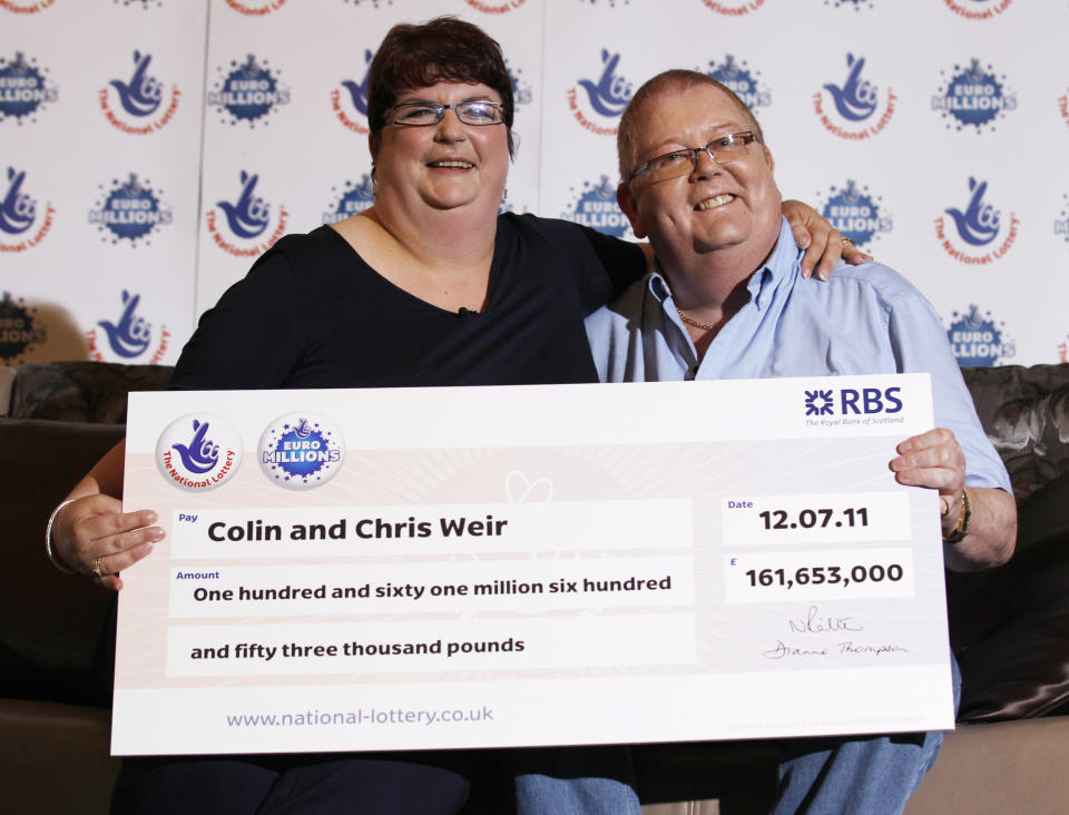 Colin Weir and his wife Chris pose for photographers during a news conference in a hotel near Falkirk, Scotland July 15, 2011. The couple scooped 161 million pounds ($259 million) in Tuesday's Euromillions jackpot.   REUTERS/David Moir (BRITAIN - Tags: SOCIETY)