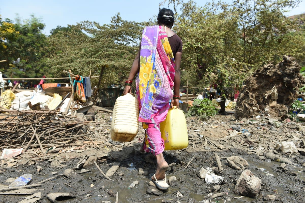 File photo: A woman carries containers filled with drinking water in Maharashtra. Frequent droughts in the region are forcing people to leave their farms and work as labourers under unfair contracts (AFP/Getty Images)