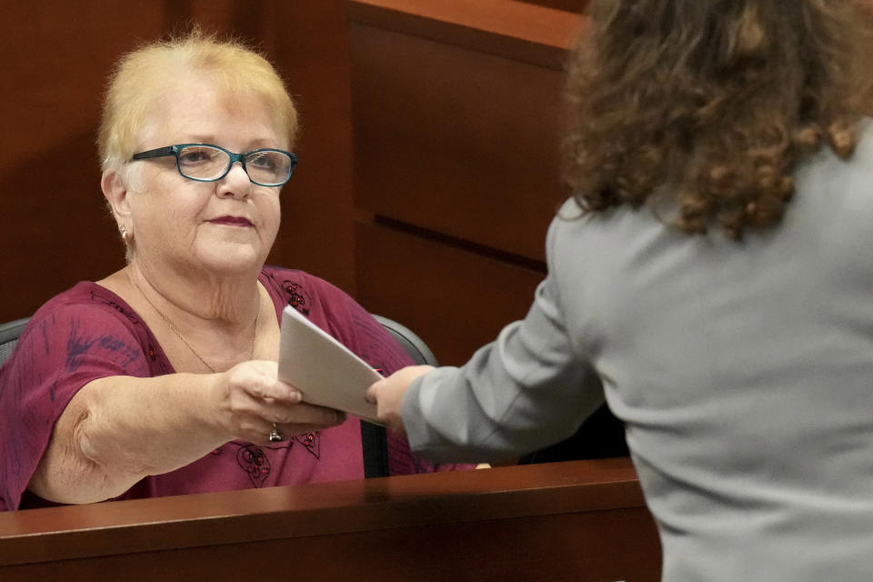 Lynn Rodriguez hands documents back to Assistant Public Defender Tamara Curtis as she testifies during the penalty phase of the trial of Marjory Stoneman Douglas High School shooter Nikolas Cruz at the Broward County Courthouse in Fort Lauderdale, Fla., Monday, Aug. 29, 2022. Rodriguez was Cruz's third and fourth grade teacher. Cruz previously plead guilty to all 17 counts of premeditated murder and 17 counts of attempted murder in the 2018 shootings. (Amy Beth Bennett/South Florida Sun Sentinel via AP, Pool)