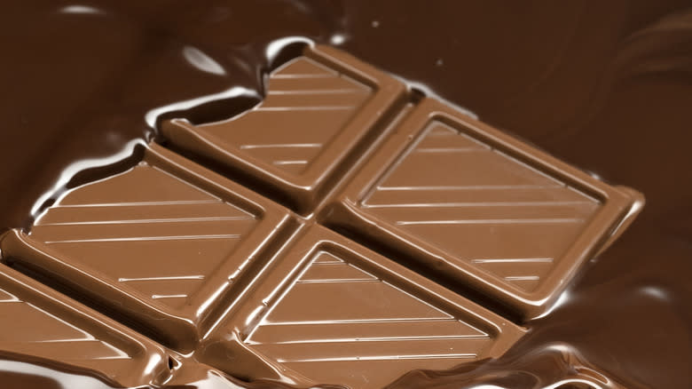 bar of chocolate surrounded by melted chocolate