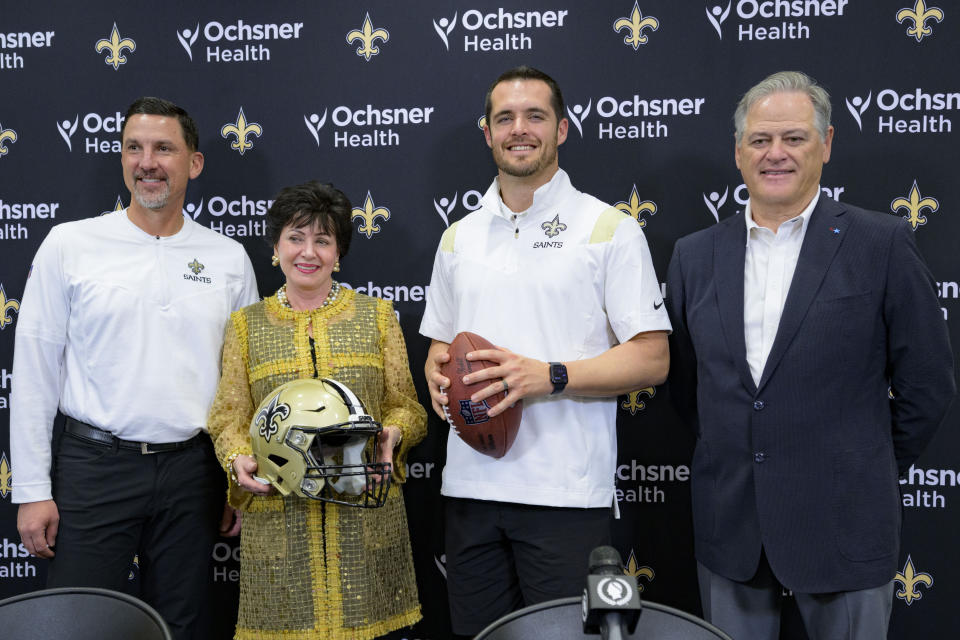 Derek Carr, second right, the new quarterback of the New Orleans poses with Saints general manager Mickey Loomis, right, head coach Dennis Allen, left, and owner Gayle Benson, second left during an NFL football press conference at the team's training facility in Metairie, La., Saturday, March 11, 2023. (AP Photo/Matthew Hinton)