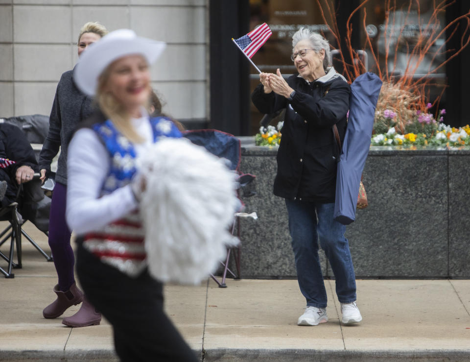 A woman cheers as a member of the Milwaukee Dancing Grannies marches by at a Veterans’ Day parade on Saturday, Nov. 5, 2022, in Milwaukee. Even blustery, cold weather doesn’t scare away the Grannies, who are an institution in the area. Members are either grandmothers or grandmother figures. They practice weekly and perform at many parades and events throughout the year. (AP Photo/Kenny Yoo)