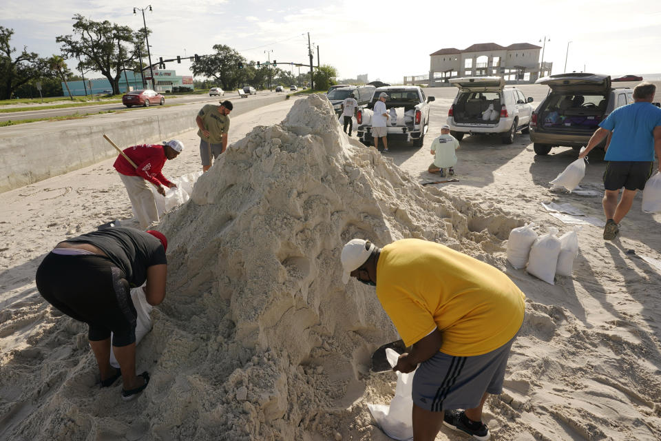 Local residents fill sand bags as they prepare for the expected arrival of Hurricane Ida Saturday, Aug. 28, 2021, in Gulfport, Miss. (AP Photo/Steve Helber)
