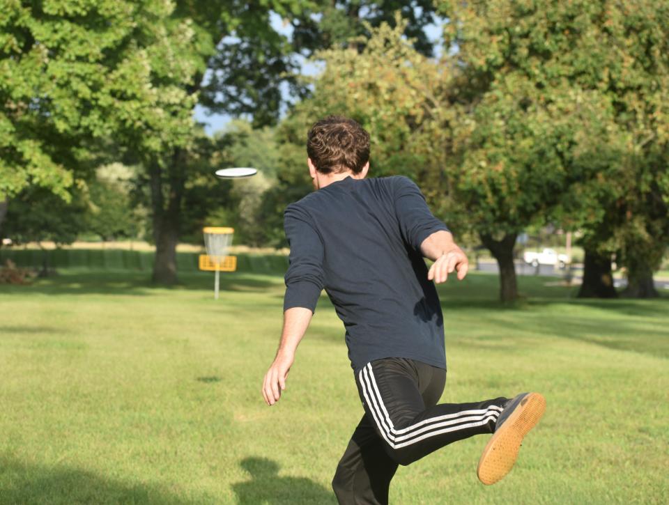 Liam Foreman of Adrian slings a throw from the tee pad Thursday while participating in a disc golf match at the course that spans the campus of PlaneWave Instruments in Adrian.