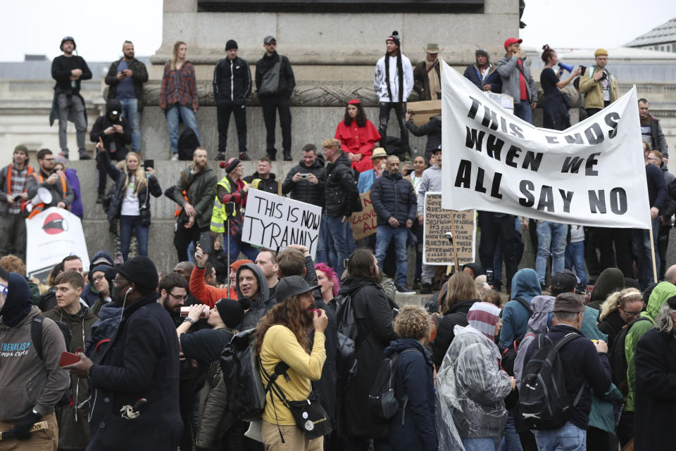 People pass through Trafalgar Square, protesting against the lockdown restrictions brought in to prevent the spread of coronavirus, in London, Saturday, Oct. 24, 2020. (Jonathan Brady/PA via AP)