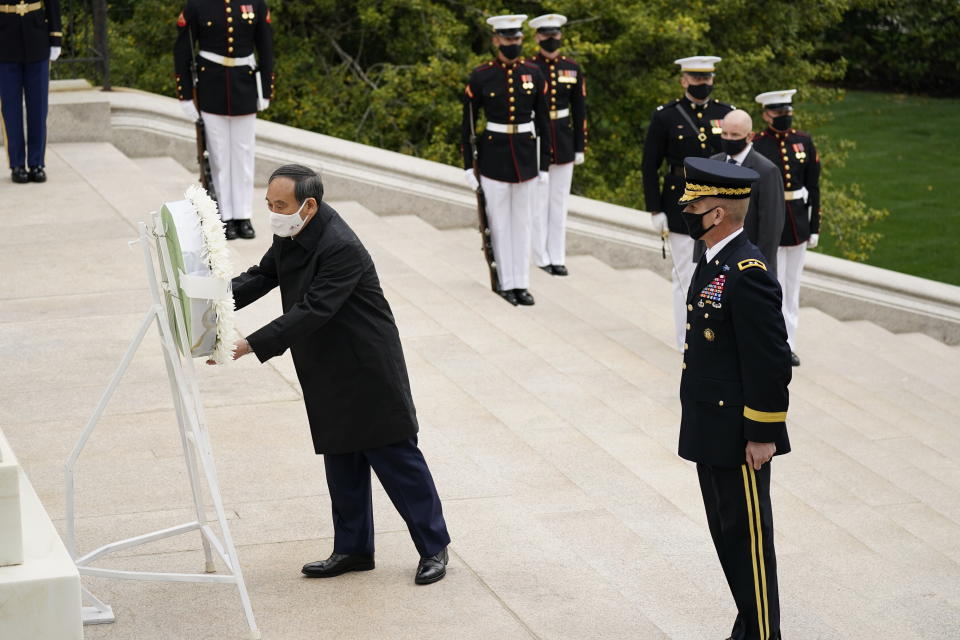 Japanese Prime Minister Yoshihide Suga places a wreath at the Tomb of the Unknown Soldier during a ceremony at Arlington National Cemetery in Arlington, Va., Friday morning, April 16, 2021, with U.S. Army Maj. Gen. Omar Jones. President Joe Biden will be welcoming Japan's prime minister to the White House on Friday in his first face-to-face meeting with a foreign leader, a choice that reflects Biden's emphasis on strengthening alliances to deal with a more assertive China and other global challenges. (AP Photo/Carolyn Kaster)