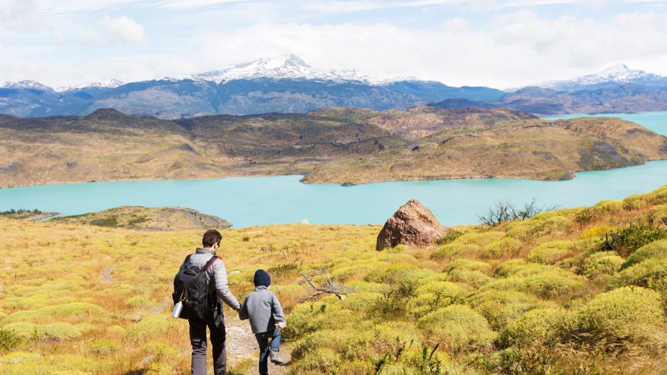 father and his son having adventure hike at torres del paine national park, patagonia, chile