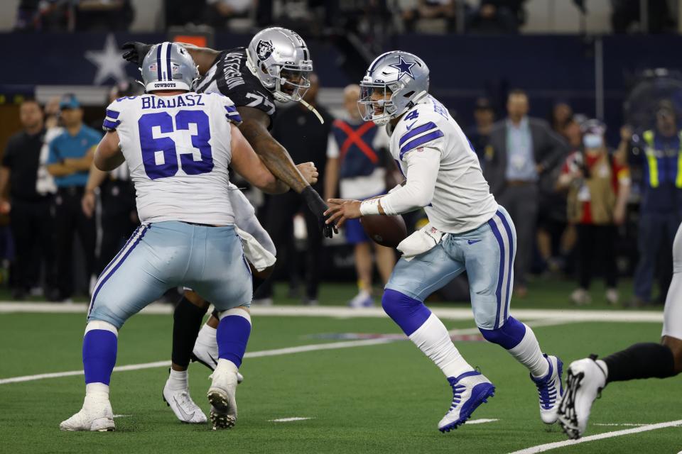 Dallas Cowboys center Tyler Biadasz (63) defends against a rush by Las Vegas Raiders' Quinton Jefferson (77) as quarterback Dak Prescott (4) scrambles out of the pocket in the second half of an NFL football game in Arlington, Texas, Thursday, Nov. 25, 2021. (AP Photo/Ron Jenkins)