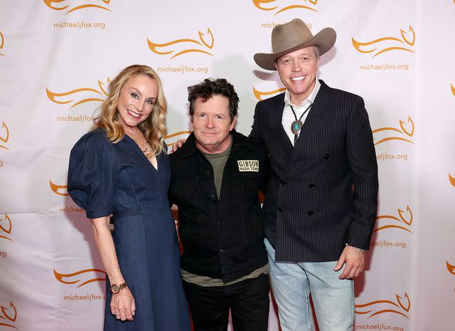 <p>Terry Wyatt/Getty</p> Tracy Pollan and Michael J. Fox with Jason Isbell