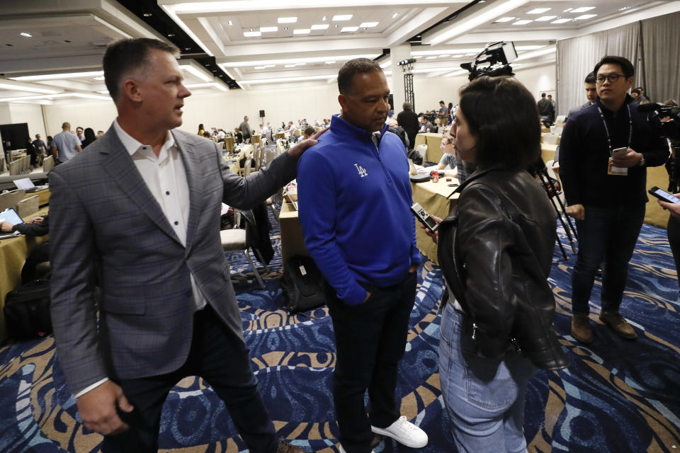 Houston Astros manager A.J. Hinch, left, greets Los Angeles Dodgers manager Dave Roberts, center, during the Major League Baseball winter meetings, Tuesday, Dec. 10, 2019, in San Diego. (AP Photo/Gregory Bull)