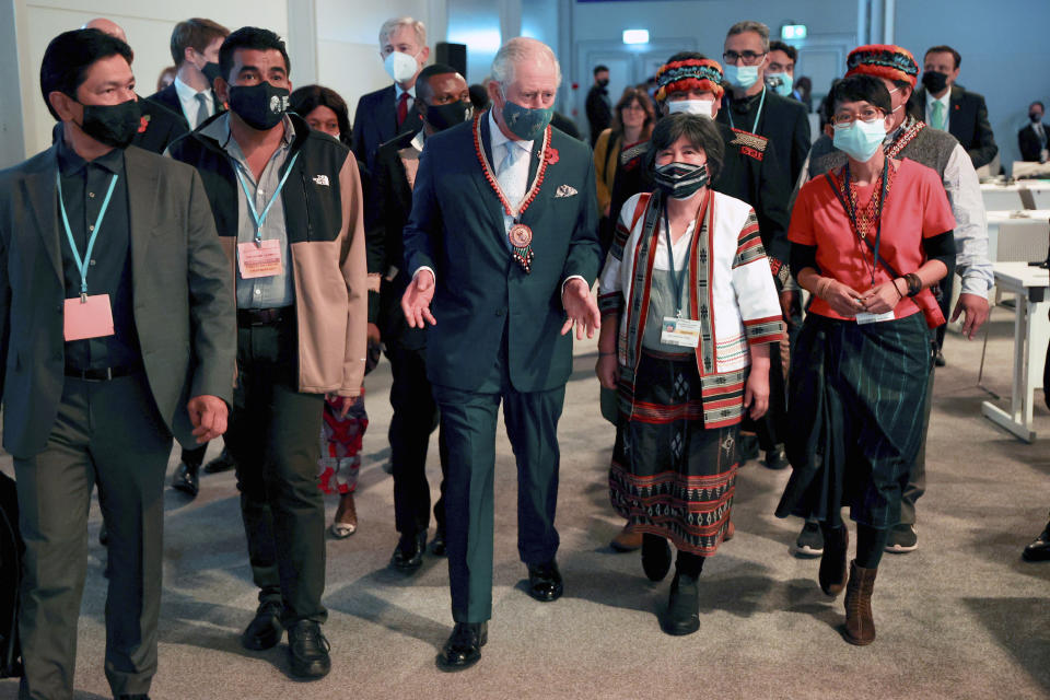 Britain's Prince Charles, center, arrives with worldwide indigenous leaders ahead of a session on Action on Forests and Land Use, during the UN Climate Change Conference COP26 in Glasgow, Scotland, Tuesday, Nov. 2, 2021. (Chris Jackson/Pool Photo via AP)