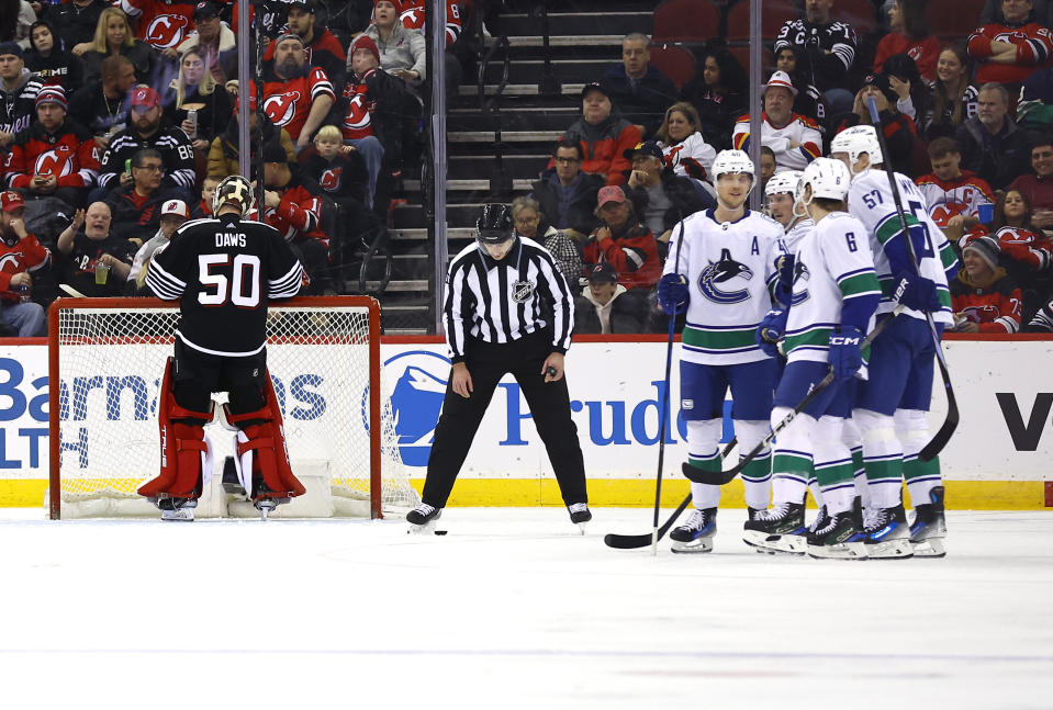 Vancouver Canucks celebrate after scoring against New Jersey Devils goaltender Nico Daws (50) during the second period of an NHL hockey game, Saturday, Jan. 6, 2024, in Newark, N.J. (AP Photo/Noah K. Murray)