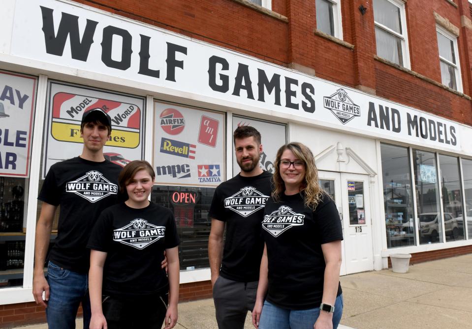 Wolf Games & Models owners Mike Wolfe, Emily Robinson, Matt Wolfe and Brittney Wolfe are pictured in front of their downtown Massillon store last week. The business has been working to overcome inflation issues by taking more of a "community approach" to attract customers.