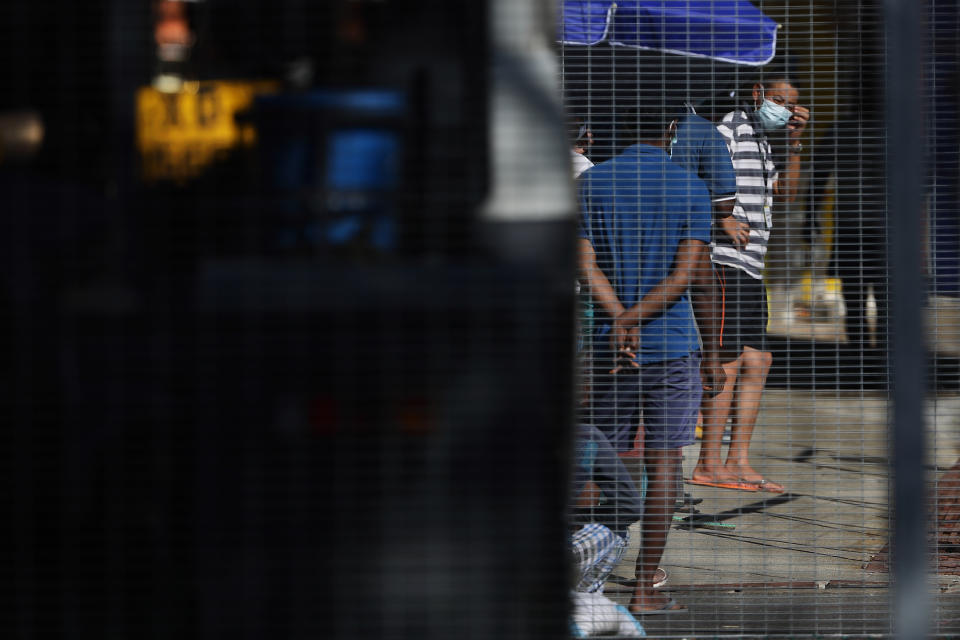 SINGAPORE - APRIL 21:  Foreign workers are seen in the compound of a dormitory on April 21, 2020 in Singapore. Singapore is now battling to control a huge outbreak in the coronavirus (COVID-19) local transmission cases among the migrant workers as it recorded a daily high of 1426 new COVID-19 cases on April 20, bringing the country's total to 8014.  (Photo by Suhaimi Abdullah/Getty Images)