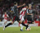 Wilson Morelo (C) of Colombia's Santa Fe fights for the ball with Leandro Desabato of Argentina's Estudiantes de La Plata during their Copa Libertadores soccer match in Bogota May 12, 2015. REUTERS/John Vizcaino